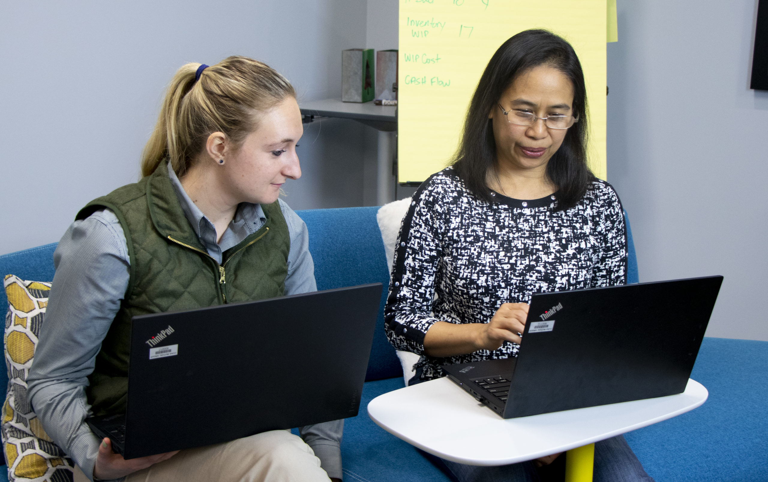 Two woman working at computers together.